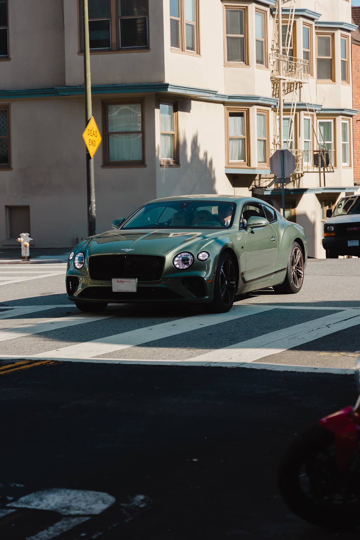 Late model Bentley Continental GT in a British Racing Green on San Francisco hills.