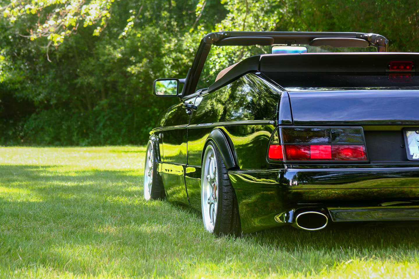 Black Saab 900 convertible with wide wheels